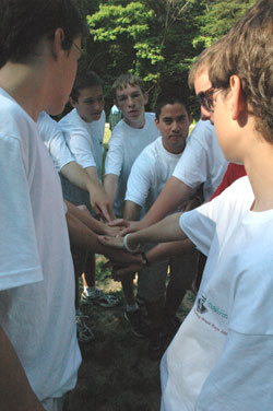 Pictured from left, Joseph Cole, 15, a member of St. Vincent de Paul Parish in Bedford; Justin Wedgewood, 16, a member of St. Mary Parish in Mitchell; and seminarian Aaron Thomas join other teenage boys in a group cheer.	