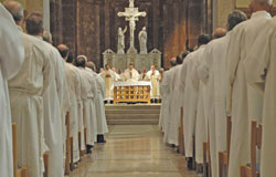 The 25 archdiocesan deacon candidates stand in prayer on Sept. 15 in SS. Peter and Paul Cathedral in Indianapolis as Archbishop Daniel M. Buechlein stands at the altar. During the Mass, the deacon candidates were instituted as acolytes.	