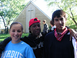 Lars Rascoe of Cathedral High School in Indianapolis drapes his arms around the shoulders of Kaylee Parsons and Paul Mpistolarides of Bishop Chatard High School in Indianapolis during a recent retreat to develop Christ-inspired leadership skills. (Photo by John Shaughnessy)