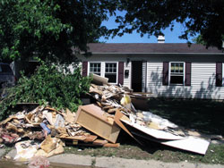 Debris lines a street in front of a flood-damaged home on June 12 in Columbus. Approximately 2,500 homes in the city were damaged by floods on June 6-7. Members of St. Bartholomew Parish in Columbus responded quickly to give aid to fellow parishioners and others affected by the flood. (Photo by David Siler)