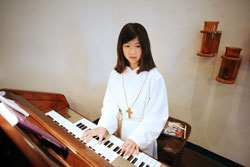 Courtney Berger, 11, plays the organ at St. Mark Church in Perry County. Courtney has accompanied the congregation’s singing at the Tell City Deanery parish since she was 9, and also often assists as an altar server during Mass. (Photo by Danny Bolin)