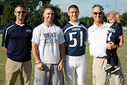 Pete Corrao began his 25 years as volunteer announcer for Our Lady of Providence Jr.-Sr. High School in Clarksville long before his three sons played football for the school. From left, his son, Phil, a 1999 Providence graduate, is now an assistant coach for the team; Spencer just finished his junior season at Hanover College; and Tony just finished his senior season at Providence. Pete holds Phil’s daughter, Reagan. (Submitted photo)