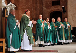 Archbishop Joseph W. Tobin welcomes the congregation to Mass at SS. Peter and Paul Cathedral in Indianapolis prior to a Catholic Community Foundation meeting and dinner on Oct. 20. Concelebrating with the archbishop are Msgr. Frederick Easton, left, Msgr. William Stumpf, Father Patrick Beidelman, Dominican Father Raymond-Marie Bryce, Father Todd Riebe, Father Robert Robeson and Father John Hall. (Photo by Natalie Hoefer) 