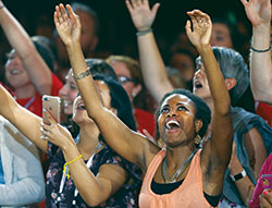 Young people lift their arms in prayer as Catholic musician Matt Maher performs on July 3 during the “Convocation of Catholic Leaders: The Joy of the Gospel in America” in Orlando, Fla. Leaders from dioceses and various Catholic organizations gathered for the July 1-4 convocation. (CNS photo/Bob Roller)