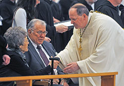 Benedictine Archabbot Kurt Stasiak, leader of Saint Meinrad Archabbey in St. Meinrad, gives a sign of peace to Marge and Charles Buechlein of Jasper, Ind., the sister-in-law and brother of Archbishop Emeritus Daniel M. Buechlein, during a Feb. 1 Mass for a Deceased Bishop in the monastery’s Archabbey Church of Our Lady of Einseideln. The Mass was part of the funeral rites for Archbishop Buechlein. (Photo by Sean Gallagher)