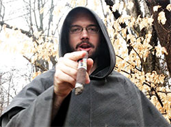 Conventual Franciscan Brother Andrew Hennessy puffs from a cigar while promoting The Man Tour, an evening in the New Albany Deanery on March 10 that will combine smoking cigars, throwing axes and participating in eucharistic adoration. (Submitted photo)