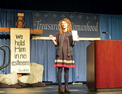 As she addresses participants at the Indiana Catholic Women’s Conference in Indianapolis on March 10, Sonja Corbitt holds up a journal she used to record her thoughts after her daily reading of Scripture. (Photo by Natalie Hoefer)