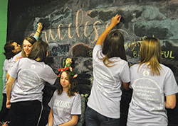 Teens write affirming words to describe Audrey Braughn, seated in the center, during the “Priceless” retreat at St. Malachy Parish in Brownsburg on April 6. Three teens of the parish designed the retreat with the help of their parish youth and campus ministries director. (Submitted photo)