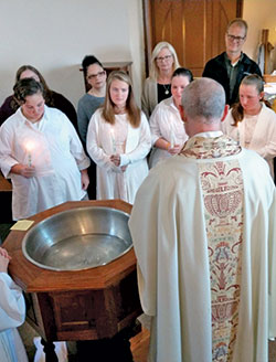 Father Christopher Wadelton, sacramental minister of Holy Trinity Parish in Edinburgh, prepares Gracie, left, Shelby, Emma and Sophia Higdon for the sacrament of baptism on Nov. 24, 2019, in Holy Trinity Church. (Submitted photo)