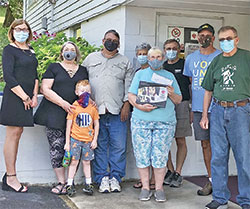 Laura Frankrone, left, a Dare to Care representative, presents a 2020 Bobby Ellison Award of Excellence to Breaking Bread volunteers. Pictured to her left are Nancy Rochner, Jackson Rochner (child), Mark Rochner, Dolores Dotson, Diane Cooper (with plaque and check), Mike Seng, Dennis Maschino and Jim Newman. (Submitted photo)