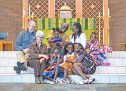 Mary and Joe Abella and Felix and Viviane Minza and their five daughters have bonded in a special way as members of St. Jude Parish in Indianapolis. (Photo courtesy of Jen Buechler of 21 DreamS Photography)