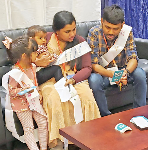 Anu and Thomson Varghese pray a family prayer with their children as part of a CatholicHOM experience on July 19 during the National Eucharist Congress in Indianapolis. The Vargheses live in the Archdiocese of Galveston-Houston, Texas. (Photo by Natalie Hoefer)