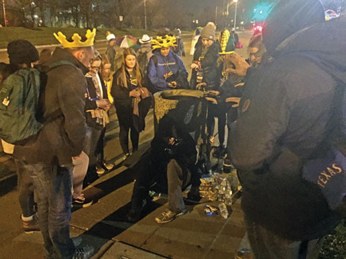 Walking to their hotel after the closing Mass for the National Catholic Youth Conference on Nov. 23, 2019, in Indianapolis, young people pray over a homeless man after stopping to offer him water and snacks. (File photo by Natalie Hoefer)