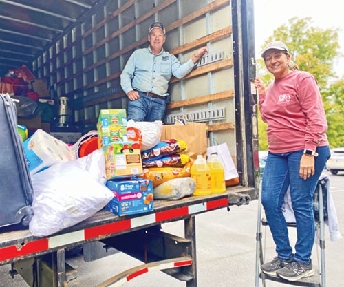 Kevin Becht, left, helps load a truck as part of a Hurricane Helene relief effort coordinated by his wife Tammy Becht, right, on Oct. 15 at St. Mary-of-the-Knobs Parish in Floyd County, where the Bechts are members. (Submitted photo)