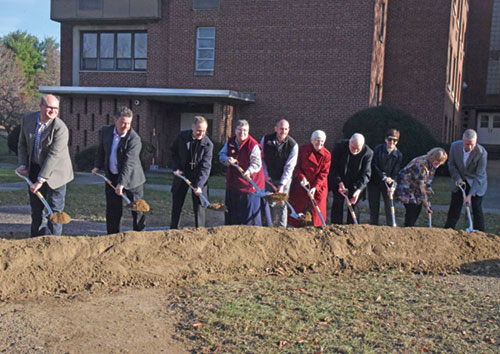 The Benedictine sisters of Our Lady of Grace Monastery in Beech Grove broke ground on Nov. 24 on a new monastery. Shoveling the dirt are, from left, Brian Ziolkowski and Michael Egan of the Browning Day architectural firm, Archbishop Charles C. Thompson, Benedictine Sister Julie Sewell, Beech Grove Mayor James Coffman, Benedictine Sister Carol Falkner, Father James Farrell, Connie Lund and Colleen Kenney of the monastery’s Lay Board of Advisers, and Phil Kenney of F. A. Wilhelm Construction. (Photo by Sean Gallagher)